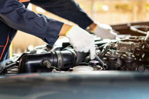 The car mechanic is checking the engine oil level.Auto mechanic Preparing For the work.Close up of hands mechanic doing car service and maintenance.Engine Maintenance concept.Auto car repair service